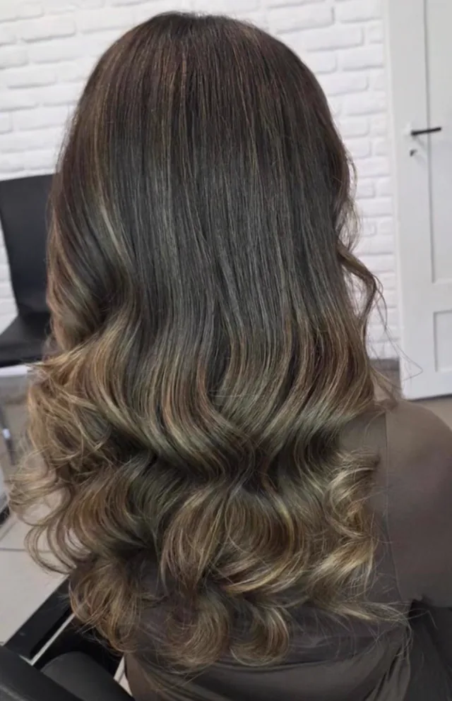 Lange Haare mit weichem Caramel-Balayage, in großen glänzenden Wellen gelegt