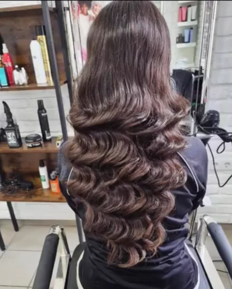 Brünettes Haar in definierten, glänzenden Wellen im Hollywood-Stil gelegt